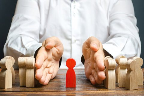 toxic people, cropped shot of man in white button down shirt using both hands to separate wooden figures - toxic people concept