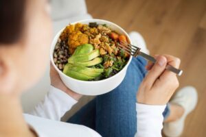 Person holding a colorful bowl of healthy food, symbolizing nutritious choices in recovery.